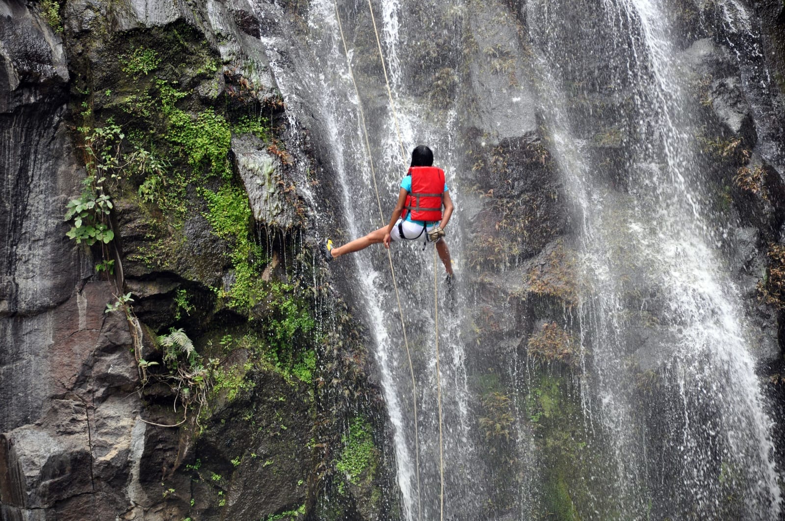 A guide rappelling a waterfall at Ribeira dos Caldeirões